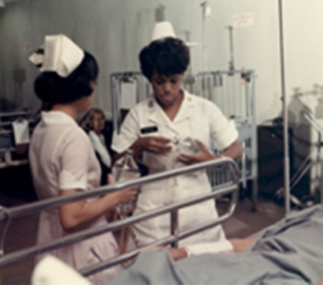 APS-71-796 Vietnam. The Army Nurse in Vietnam. Cpt. Theora L. Peyton (Arlington, VA), changes an intravenous saline bottle on a patient at the 3rd Field Hospital. 12 July 1971. Photo by SP5 Logan McMinn, USA Sp Photo Det, Pac, fn